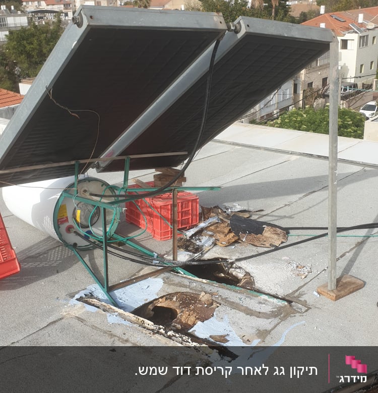 קולטי שמש ומיכל מים על גג עם נזקי רטיבות